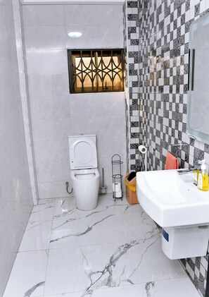 Un baño con inodoro, bidé y lavabo.