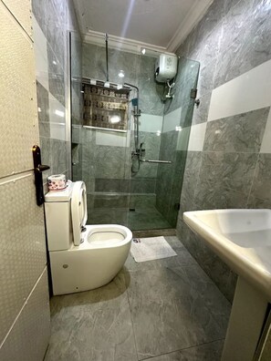 Een douche, handdoeken, zeep, toiletpapier