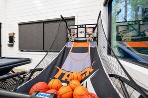 En basketballbane med net, bolde og en væg med et vindue.