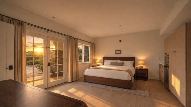 A bedroom with a bed, bedside tables, a desk, a wardrobe, and a sliding glass door to a balcony. - Bella Notte by the beach Studio 2 (Pleasure Point)