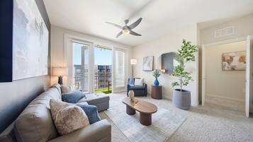A modern living room with a sofa, coffee table, and a ceiling fan.