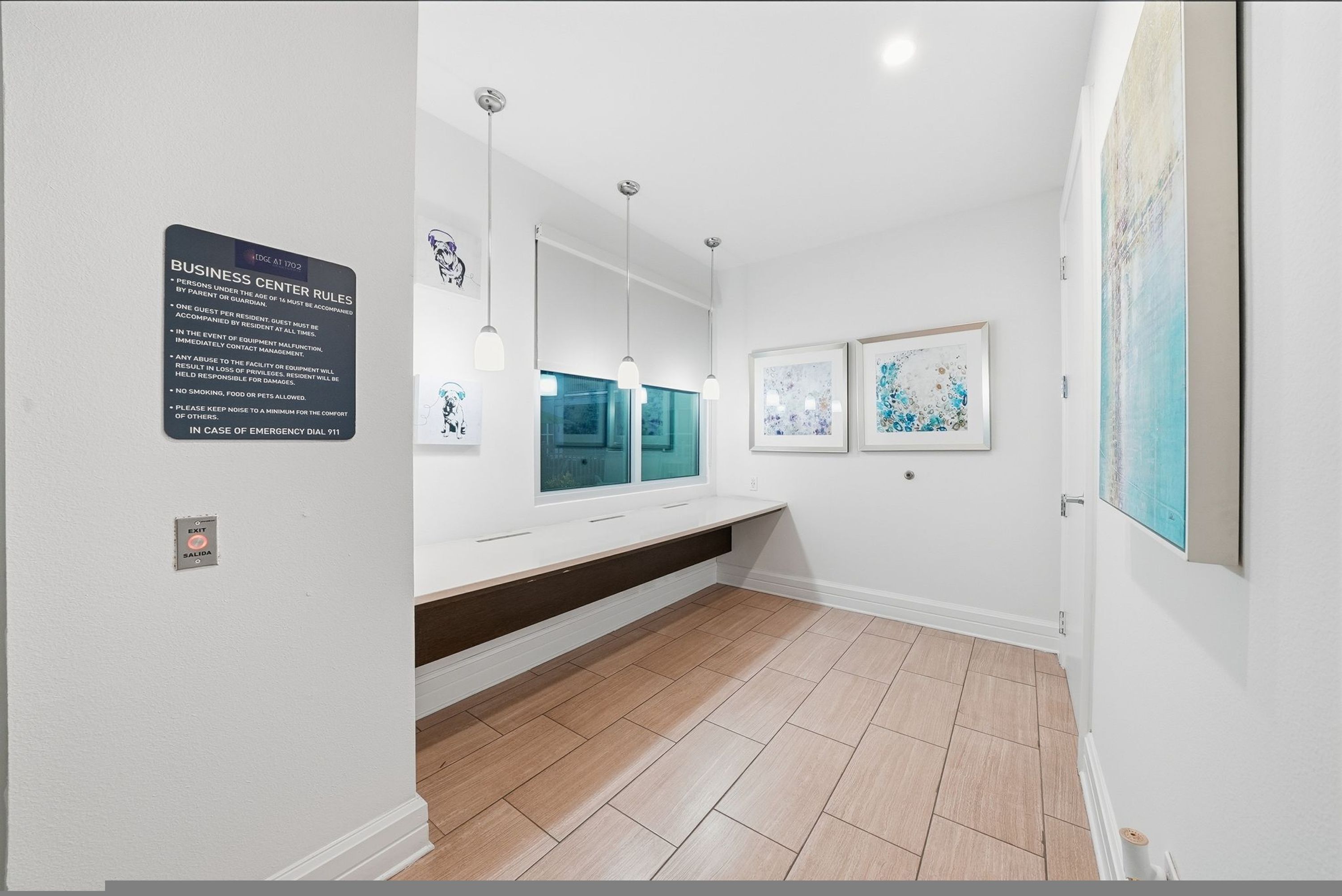 A clean, modern room with a white wall, a wooden floor, a large mirror, and artwork.
