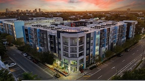 A multi-story residential building with a rooftop terrace, a gated entrance, and a parking area. - Stylish 2BR w Balcony Pool Pet-friendly 15 (Tampa)