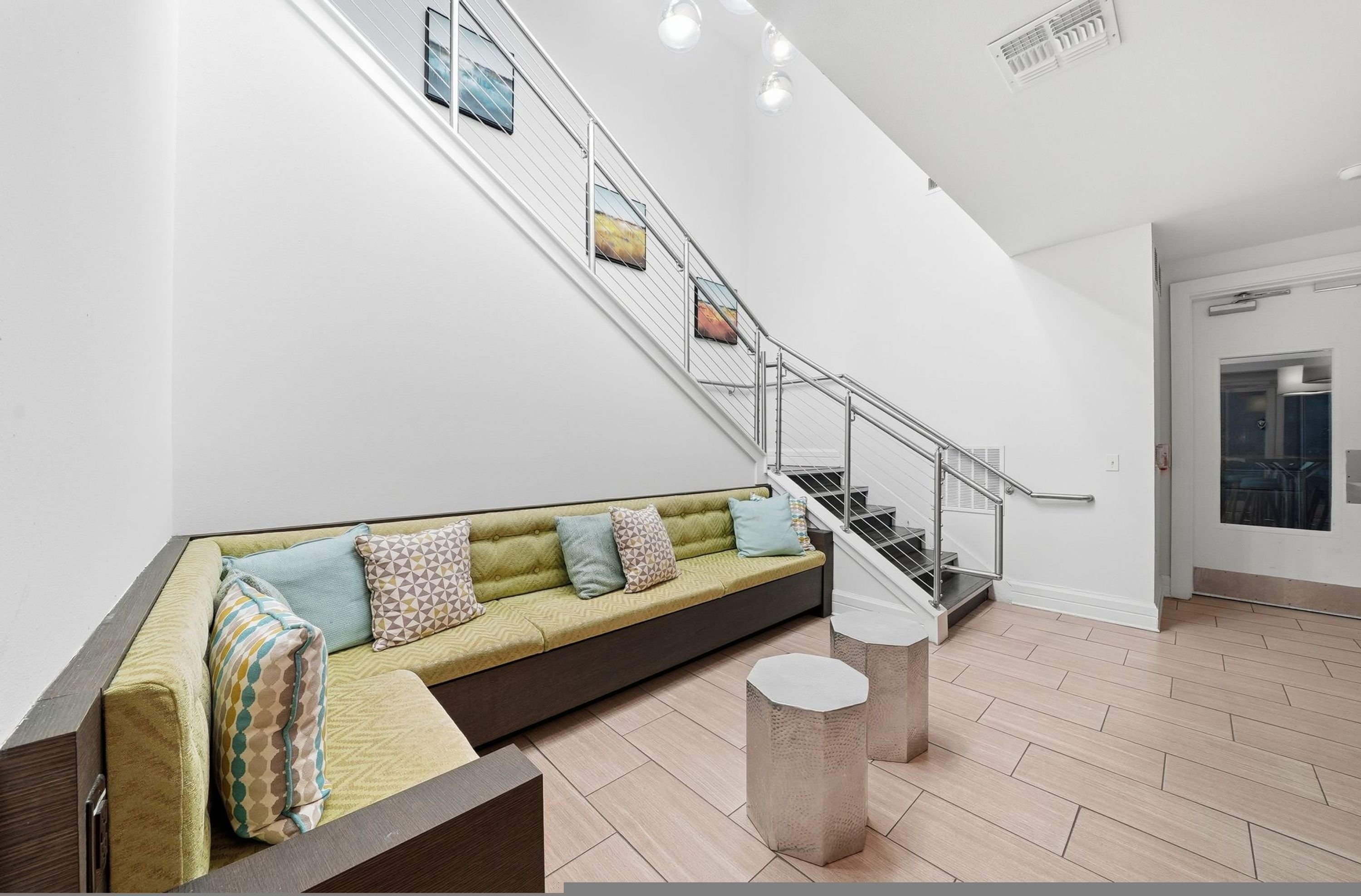 Um interior moderno com um sofá, uma escada e uma porta.