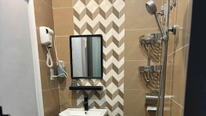 A compact bathroom with a toilet, sink, mirror, and shower. - Home Nha Gao Da Lat (Xuan Huong - Da Lat)