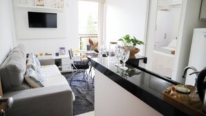Een moderne keuken met een flatscreen televisie, een zithoek met een bank en uitzicht op de omgeving.