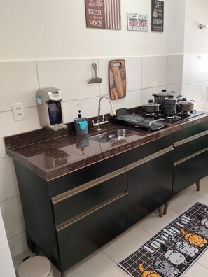 A modern kitchen with a granite countertop, stainless steel appliances, and a built-in oven. - Cabo Branco Beach. A fully equipped, brand-new, and comfortable apartment. Up to 7 people. (João Pessoa)
