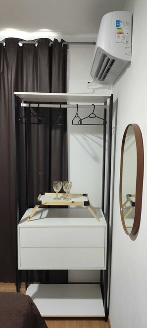 A compact room with a bunk bed, a small vanity with a mirror, a bedside table, and a wall-mounted air conditioner. - Cabo Branco Beach. A fully equipped, brand-new, and comfortable apartment. Up to 7 people. (João Pessoa)
