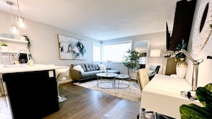 Un salon moderne comprenant un canapé, une table basse et un coin repas avec une table et des chaises.