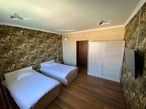 Habitación con 2 camas individuales, varias camas, vista al jardín | Caja de seguridad en la habitación y insonorización 