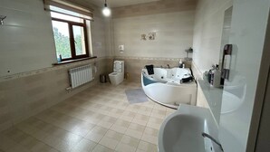 Un baño con bañera, inodoro y ventana.