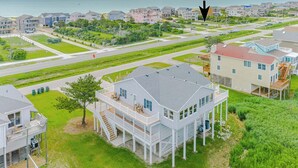 Una zona residencial costera con casas, una calle y vistas al océano.