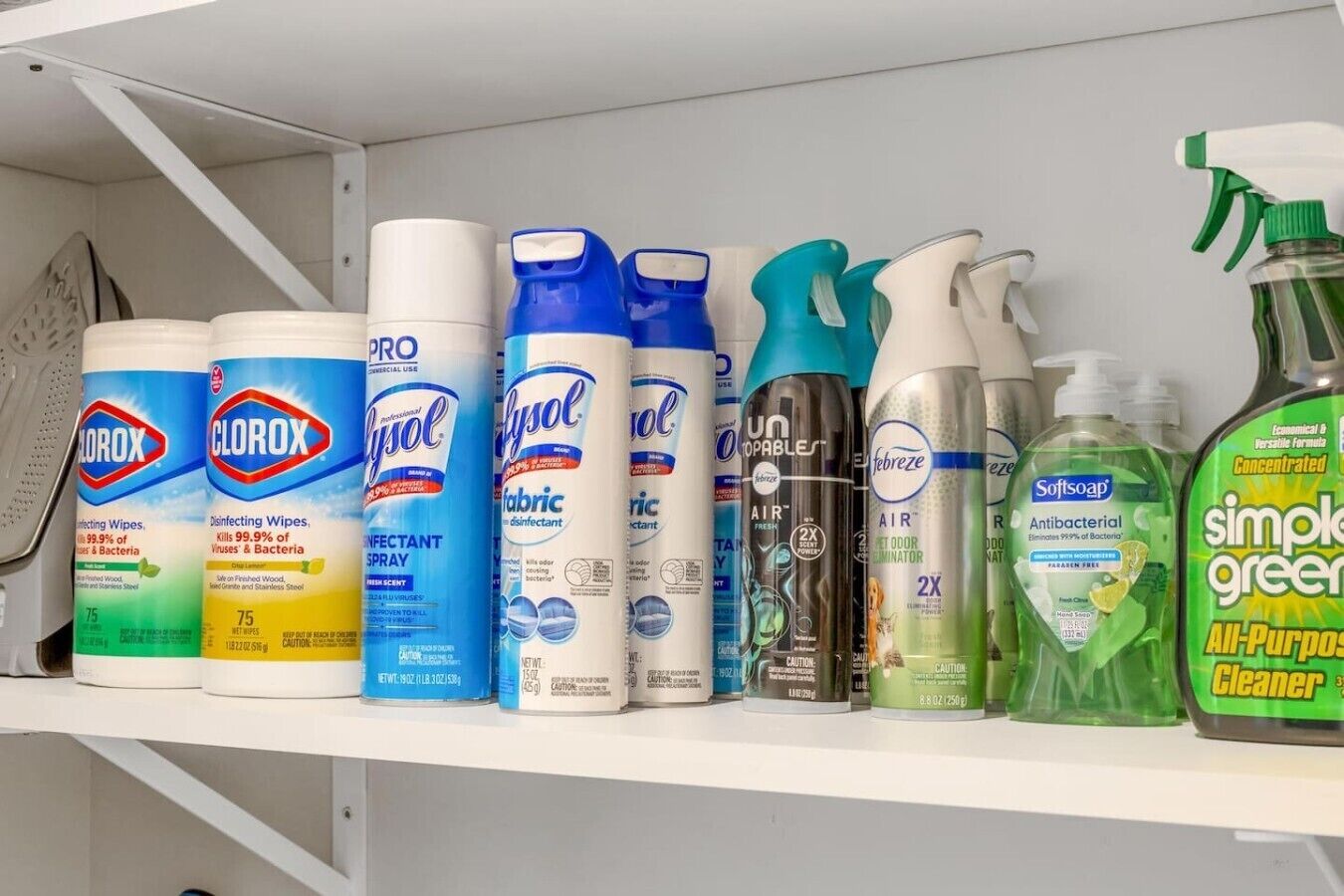 Une étagère contenant divers produits de nettoyage, notamment un désinfectant en aérosol de la marque Lysol, des lingettes désinfectantes de la marque Clorox et un désodorisant d’ambiance de la marque Febreze.