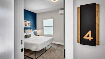 A beautifully lit, queen-sized bedroom with modern touches.