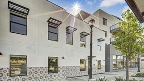 Un edificio moderno con numerose finestre, una facciata decorata e un lampione di strada.
