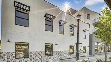A modern building with multiple windows and a patterned tile design at the base.