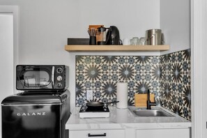 Eine Küche mit einem Galanz-Toaster, einem Wasserkocher, einer Spüle und einer Wandfliesenrückwand mit Muster.