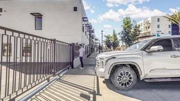 A gated parking area with a white SUV parked on the right.