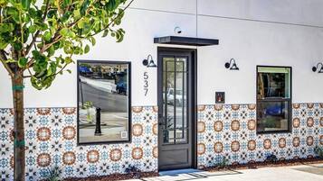 Fachada de edificio con un número, una puerta y baldosas estampadas.