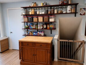 A kitchen with wooden cabinets, a wooden countertop, and a baby gate. - The Restful Retreat - Spacious Home (Moscow)