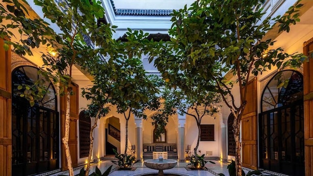 An indoor courtyard with a central fountain, surrounded by trees and columns. - The Riad Saeed (Marrakech)
