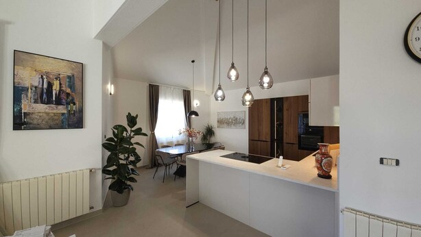 A modern kitchen with pendant lights, a dining area, and a living space. - New Elegant Luxury Villa Viktoria in Historic Pula (Pula)