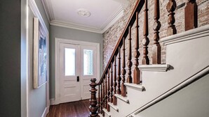 A staircase with wooden balusters and a white handrail, leading to a door with a window. - Experience Portland’s charm in this beautifully restored 2-bed, 1.5-bath Victorian apartment! Located downtown, enjoy modern comforts, historic elegance, a private backyard, AC, and 1 free parking spot. Perfect for your Maine getaway! 🦞 (Portland)