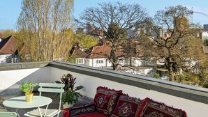 A rooftop terrace with a sofa, chairs, and a small table. - 6 bedroom spacious house minutes from Wembley Stadium (Wembley)