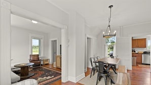 A spacious living room with a dining area, hardwood floors, and a view of the outdoors. - Charming Hudson Farmhouse with Fire Pit (Hudson)