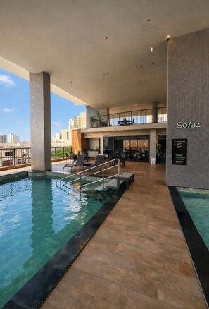 Ein moderner Innenpoolbereich mit freiem Blick zum Himmel, eine Lounge mit Sitzgelegenheiten und ein Schild mit der Aufschrift 'So/az'.
