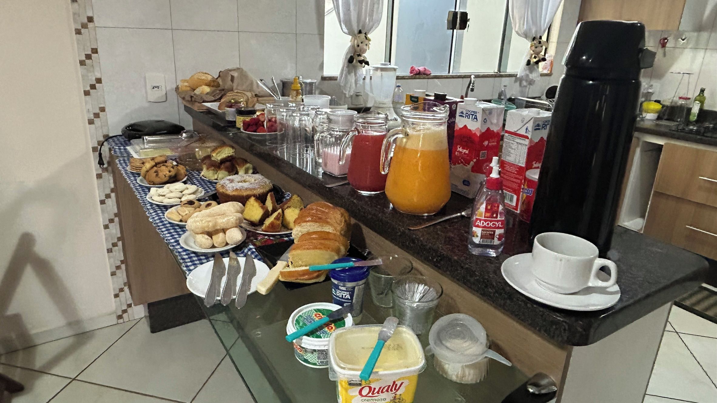 Ein Frühstücksbuffet mit verschiedenen Backwaren, einer Kaffeemaschine und Beilagen.