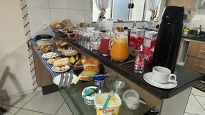 Un buffet de petit-déjeuner proposant diverses pâtisseries, une machine à café et des condiments.