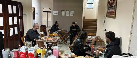 A dining area with tables, chairs, and various food items.