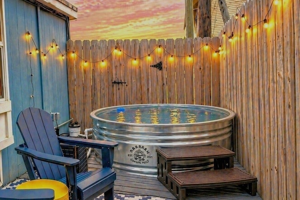 Private patio with heated/chilled pool, string lights, and cozy seating