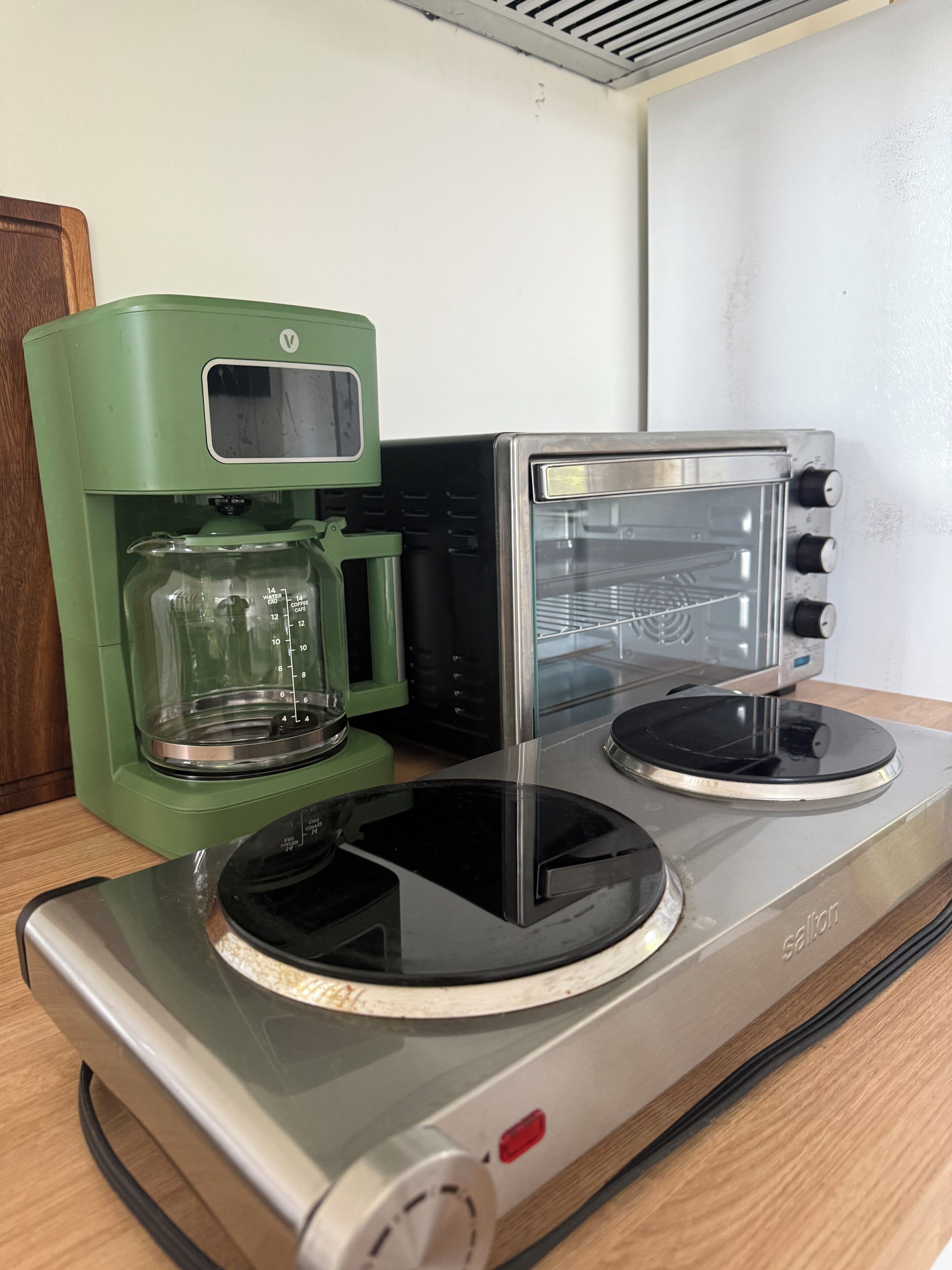 Een keuken met een koffiezetapparaat, een broodrooster en een fornuis.