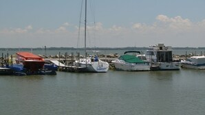 A marina with various boats docked, including a sailboat with a tall mast. - Grand Beach 3BR Villa # 11 at South Beach Resort (Lakeside Marblehead)