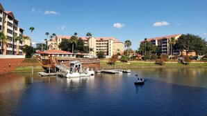 A waterfront hotel with a dock, boats, and palm trees. - Luxurious resort stay with amazing all-inclusive amenities near Orlando Florida! (Kissimmee)