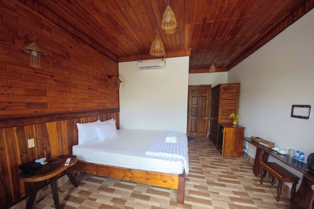 Una habitación con paneles de madera, una cama, un escritorio y un armario.