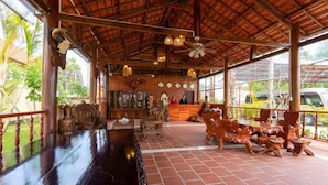 A covered outdoor area with a dining table, chairs, and a ceiling fan. - Serene Resort in Bai Vong Phu Quoc (Phu Quoc)