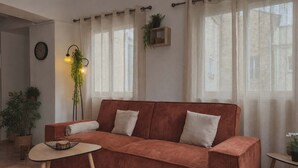 Una sala de estar con sof á, una mesita y plantas en macetas.
