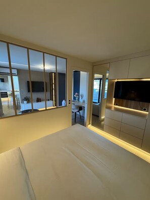 A hotel room with a bed, a TV, a mirror, and a view of the dining area. - Terrace 20 m2 Top Floor - 2-room apartment (Nice)