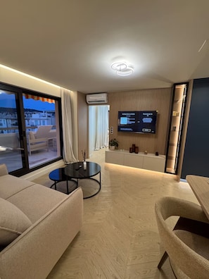 A modern living room with a TV, sofa, and dining area. - Terrace 20 m2 Top Floor - 2-room apartment (Nice)