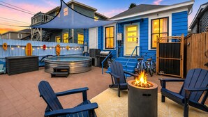Ein Garten mit Whirlpool, Sitzgelegenheit und Feuerstelle.