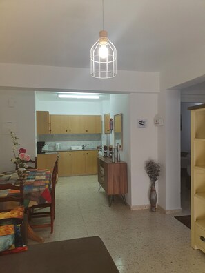 Un coin repas avec une table, des chaises et un vase de fleurs.