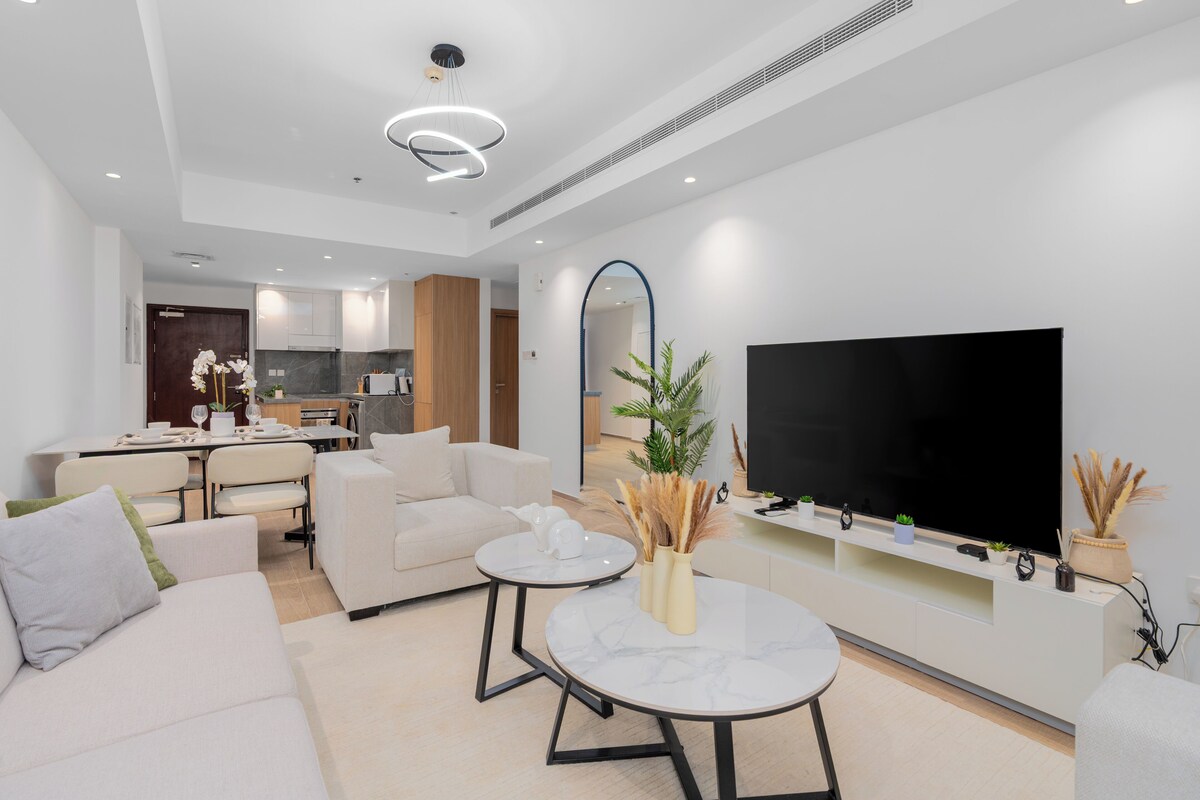 Ein modernes Wohnzimmer mit einer Couch, einem Couchtisch und einem Flachbildfernseher.