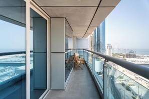 Un balcón con vista a la ciudad, incluyendo edificios altos y una masa de agua.