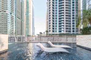 Ein modernes Hochhaus mit Schwimmbad und dekorativen Schwänen.