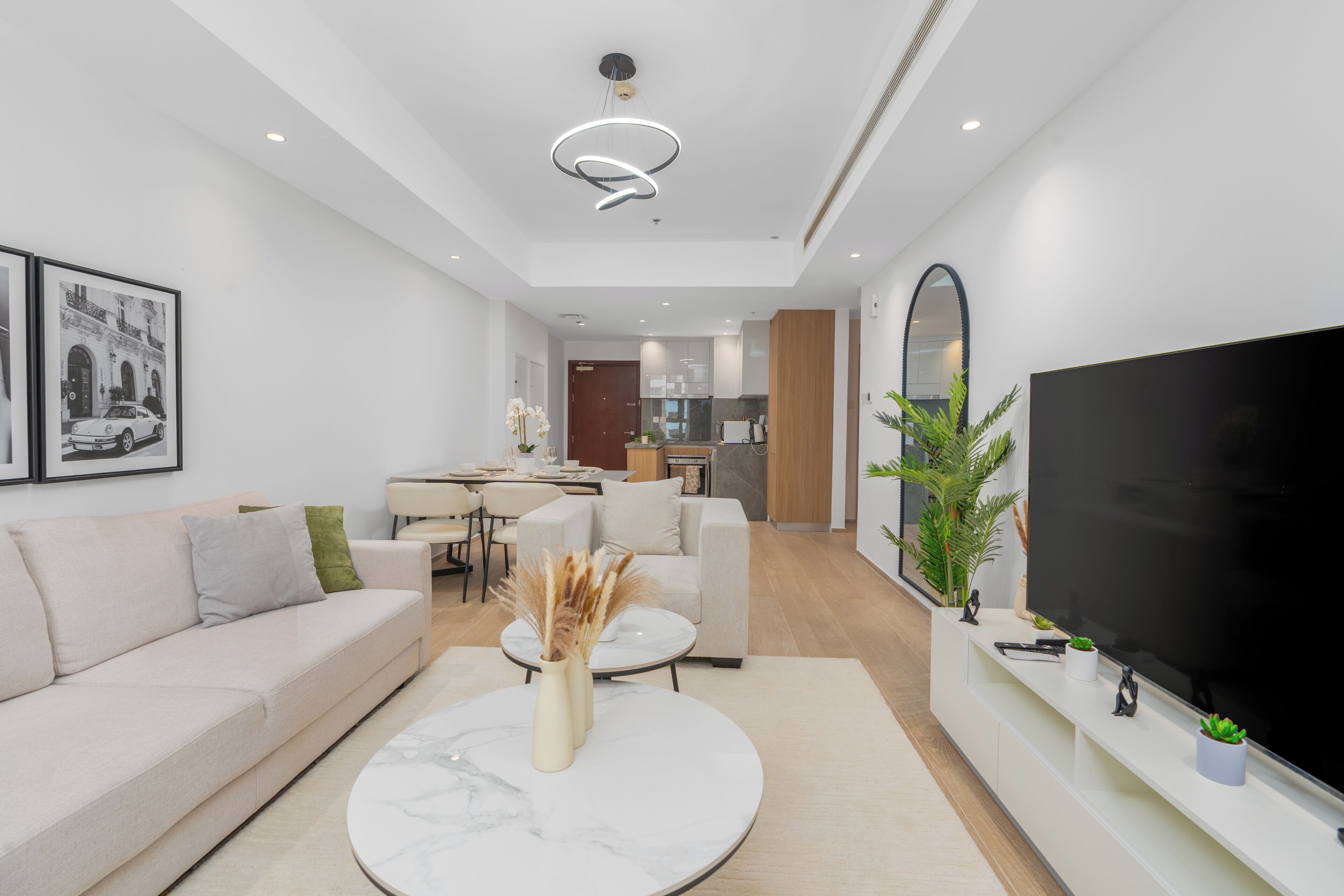 Un salon moderne avec un canapé, une table basse et un téléviseur à écran plat.
