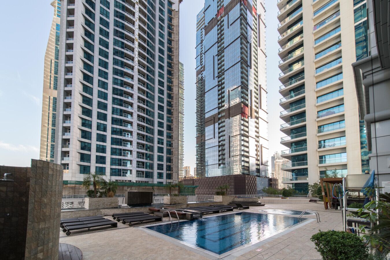 Um complexo moderno de edifícios altos com piscina e área de lazer.