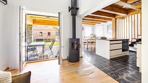 A modern kitchen with a central island, a built-in stove, and a dining area with a table and chairs.